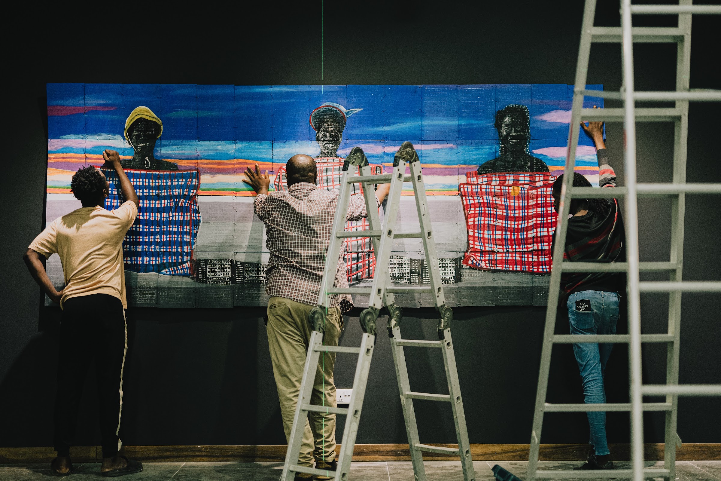 People collaborating on a wall of artwork at a buro. workshop