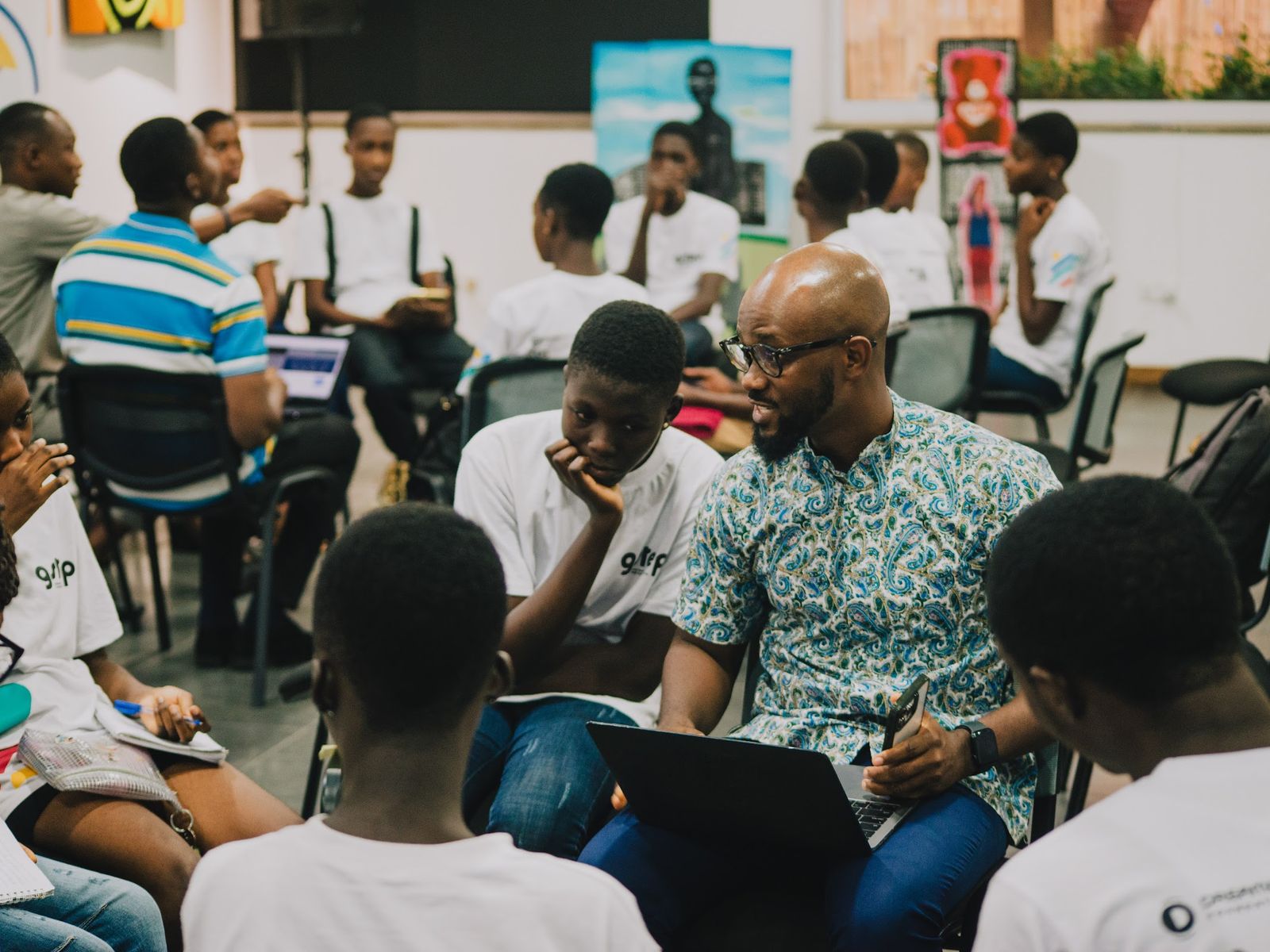 Workshop circle at a modern African coworking space, participants collaborating around a speaker with a laptop, photo from the buro. album